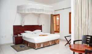 朱巴Aron International Hotel的一间卧室配有一张带天蓬的大床