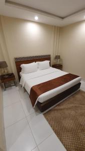 延布منتجع شاطئ الدولفين للإيواء السياحي的一间卧室设有一张大床和两个床头柜