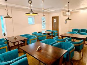 卡基纳达De Crown Luxury Hotel的餐厅设有木桌和蓝色椅子