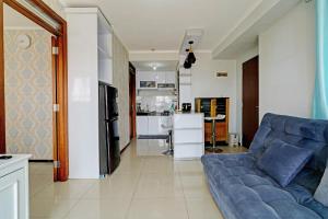 万隆OYO Life 93097 Apartemen Gateway Pasteur By Kaisar Room的一间带蓝色沙发的客厅和一间厨房