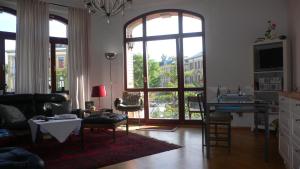 德累斯顿菲德勒别墅公寓的客厅设有大窗户和桌椅