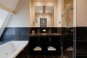 阿姆斯特丹罗默阿姆斯特丹酒店 的一间带水槽、浴缸和镜子的浴室