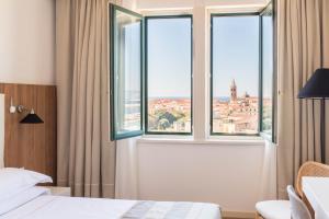 阿尔盖罗伽泰罗尼亚酒店的一间卧室设有窗户,享有城市美景