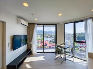 邦涛海滩Skypark Laguna apartments Bangtao的客厅设有桌子和大窗户