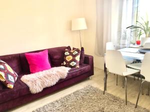 赫尔辛基Scandinavian Desing Home 37 City Center in Kamppi的客厅配有带粉红色枕头的紫色沙发