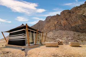 艾恩Pura Eco Retreat, Jebel Hafit Desert Park的沙漠中一座有山的建筑