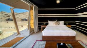 艾恩Pura Eco Retreat, Jebel Hafit Desert Park的一间带沙发床的卧室,享有沙漠美景
