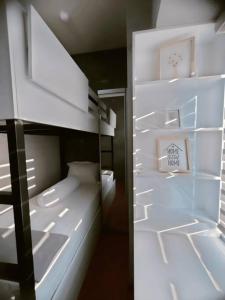 泗水Tanglin Orchard Apartment (2BR)的客房内的一张带镜子的白色双层床