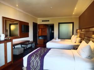 努沙杜瓦巴厘岛美乐滋度假酒店的酒店客房配有两张床和一张书桌