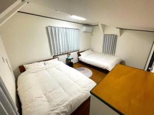 东京Tatami house Skytree view Asakusa line的小房间设有两张床和一张桌子