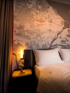 日内瓦IntercityHotel Geneva的酒店客房设有一张床,墙上挂有地图