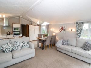 科克茅斯No 7 Skiddaw View的客厅配有2张白色沙发和1张桌子