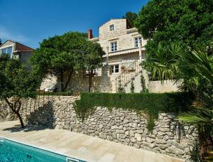 特斯特诺Villa Lemonia的一座房子,设有石墙,毗邻游泳池
