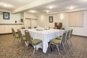 特鲁罗速8特鲁罗酒店的一间会议室,配有白色的桌子和椅子