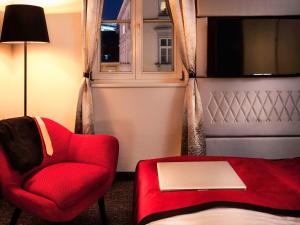 维也纳维也纳美居第一酒店的客厅配有红色椅子和窗户