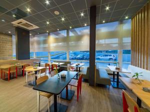 马瑙斯ibis Manaus Aeroporto的一间带桌椅的餐厅,享有停车场的景致