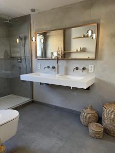 默桑西Charming house on the Luxembourg border的一间带水槽、镜子和卫生间的浴室