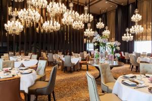 新加坡Hilton Singapore Orchard的一间设有白色桌子和吊灯的用餐室