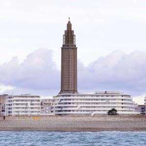勒阿弗尔Hilton Garden Inn Le Havre Centre的水面上一座带钟楼的大型建筑