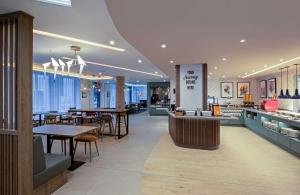 巴斯Hampton By Hilton Bath City的一间带桌椅的餐厅和一间酒吧