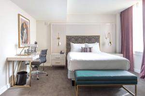 伯明翰The Kelly Birmingham, Tapestry Collection By Hilton的配有一张床和一张书桌的酒店客房