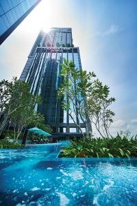 莎阿南Doubletree By Hilton Shah Alam I-City的一座高大的建筑,前面有一个游泳池