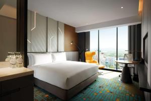莎阿南Doubletree By Hilton Shah Alam I-City的配有一张床、一张书桌和一扇窗户的酒店客房