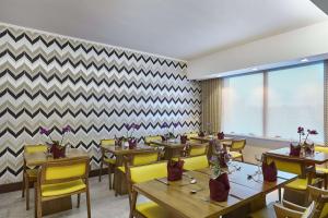 阿雷格里港Hilton Porto Alegre, Brazil的餐厅设有木桌和黄色椅子