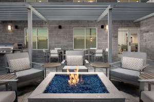 德斯坦Homewood Suites By Hilton Destin的一个带火坑和椅子及烧烤架的庭院