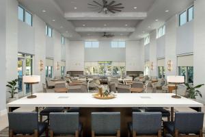 德斯坦Homewood Suites By Hilton Destin的大型等候室,配有大桌子和椅子