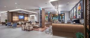普罗夫迪夫Doubletree By Hilton Plovdiv Center的餐厅设有酒吧和桌椅