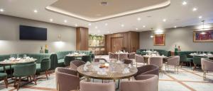普罗夫迪夫Doubletree By Hilton Plovdiv Center的餐厅设有桌椅和平面电视。