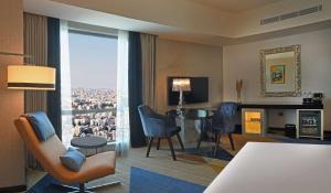 安曼Hilton Amman的客厅配有桌椅和大窗户