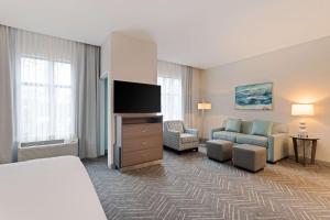 巴拿马城海滩Homewood Suites By Hilton Panama City Beach, Fl的配有一张床和一台平面电视的酒店客房