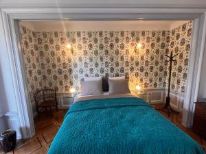 纳沙泰尔Le Faubourg 29的一间卧室配有一张带蓝色棉被的床