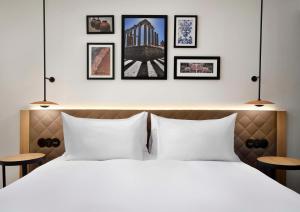 埃武拉Hilton Garden Inn Evora的卧室配有一张白色床,墙上挂有4张照片