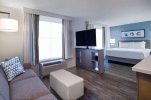 科罗拉多斯普林斯Hyatt House Colorado Springs Airport的酒店客房设有沙发、床和电视。