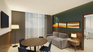阿拉胡埃拉Hilton Garden Inn San Jose Airport City Mall的客厅配有沙发和桌子