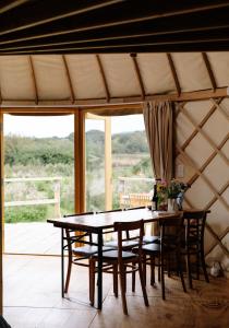 GodshillTree Field Yurt at Moor Farm的蒙古包内带桌椅的用餐室