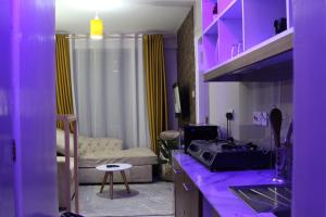 KiambuArtsy Urban 1Br along Kiambu Road with a pool and scenic views的紫色照明的厨房和客厅
