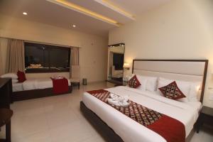 瑞诗凯诗Hotel Indira Nikunj的酒店客房设有两张床和大窗户。