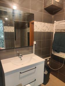 圣路易Chambre climatisée et cosy Auberge du manala Hôtel 24 24的浴室设有白色水槽和镜子