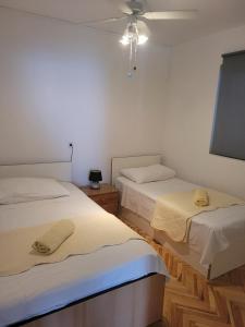 苏提万Apartments with a parking space Sutivan, Brac - 5629的白色墙壁客房的两张床