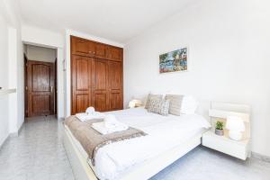 拉戈斯Lagos Sea View by Algarve Golden Properties的白色卧室设有一张带木门的大床
