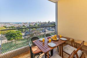 拉戈斯Lagos Sea View by Algarve Golden Properties的阳台配有木制桌椅,享有美景。