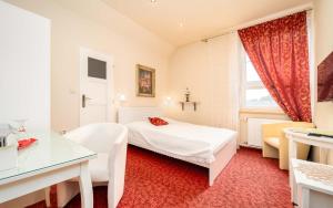 新伊钦斯卡尔卡奇酒店的一间卧室配有一张床、一张书桌和一个窗户。