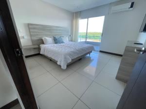 蓬塔雷纳斯Puerto Azul Hotel & Marina的一间卧室设有一张床和一个大窗户
