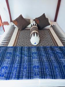 日惹ZEN MOON Hostel的一张带蓝色和白色棉被和枕头的床