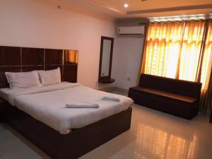 古瓦哈提HOTEL SHIVA的一间卧室配有一张大床和一张沙发
