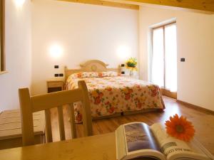 加尔达湖滨Agritur Girardelli的一间卧室配有一张床和一张桌子及一本书